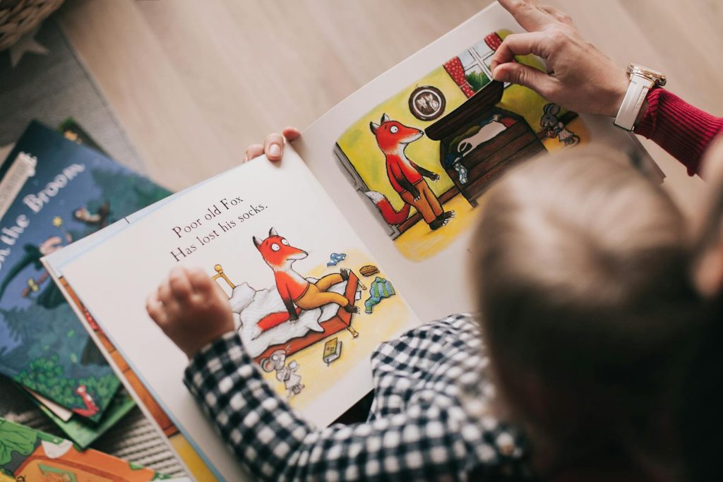 Premier Writer Cruz Tells Teachers to Make Catch-up Fridays Simple While Achieving Purpose 7 A child and adult reading an illustrated storybook together in a cozy setting.