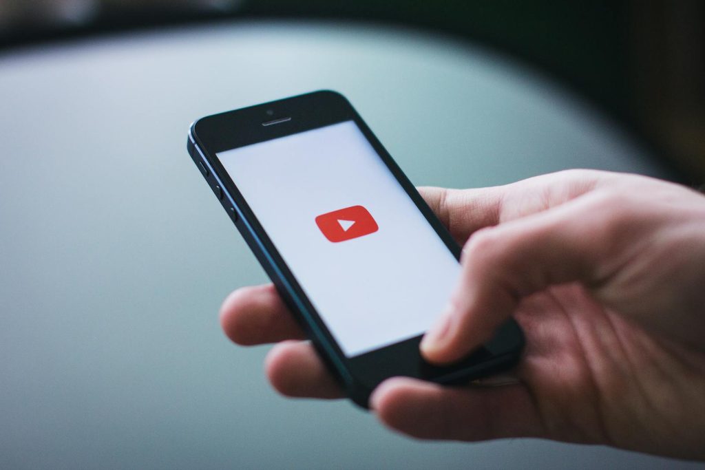 Genius Ways on How to Integrate Alternate Media to Learning and Max Learning Potential 7 Close-up of a hand holding a smartphone displaying the YouTube app on the screen.