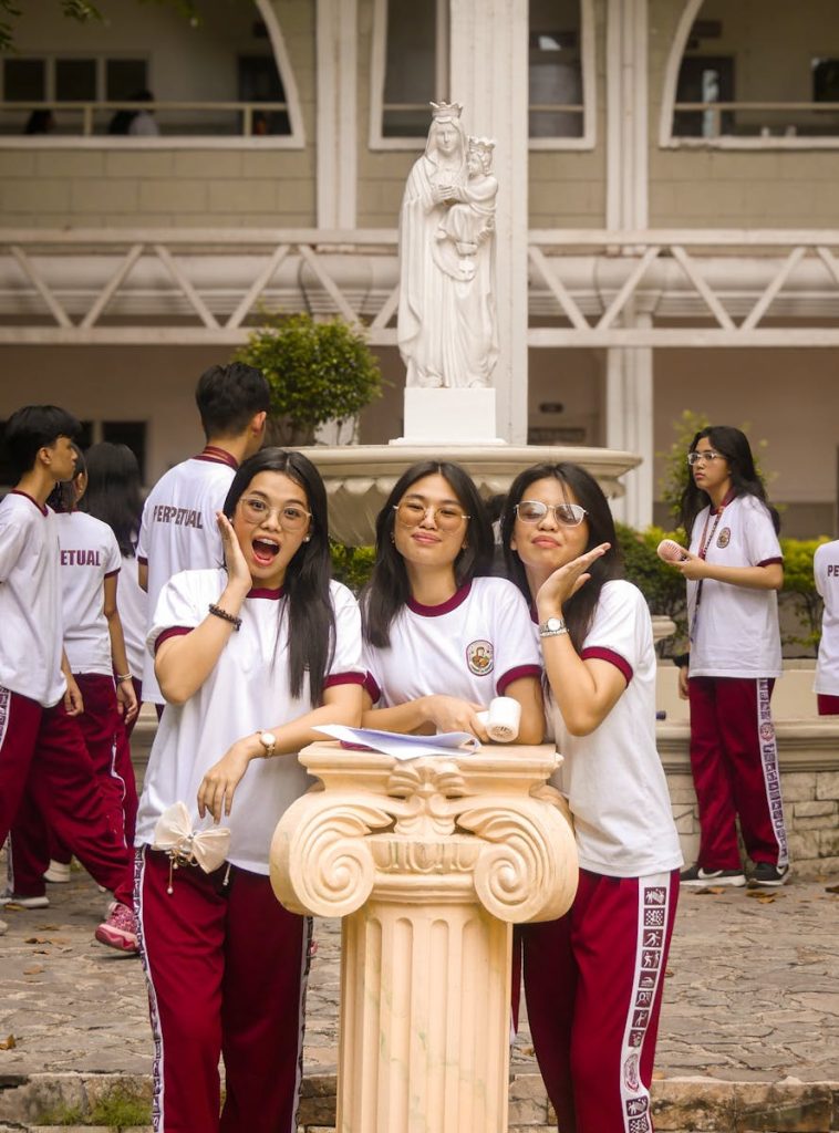 A lively group of young female students in uniform on university campus in Las Piñas, Philippines.