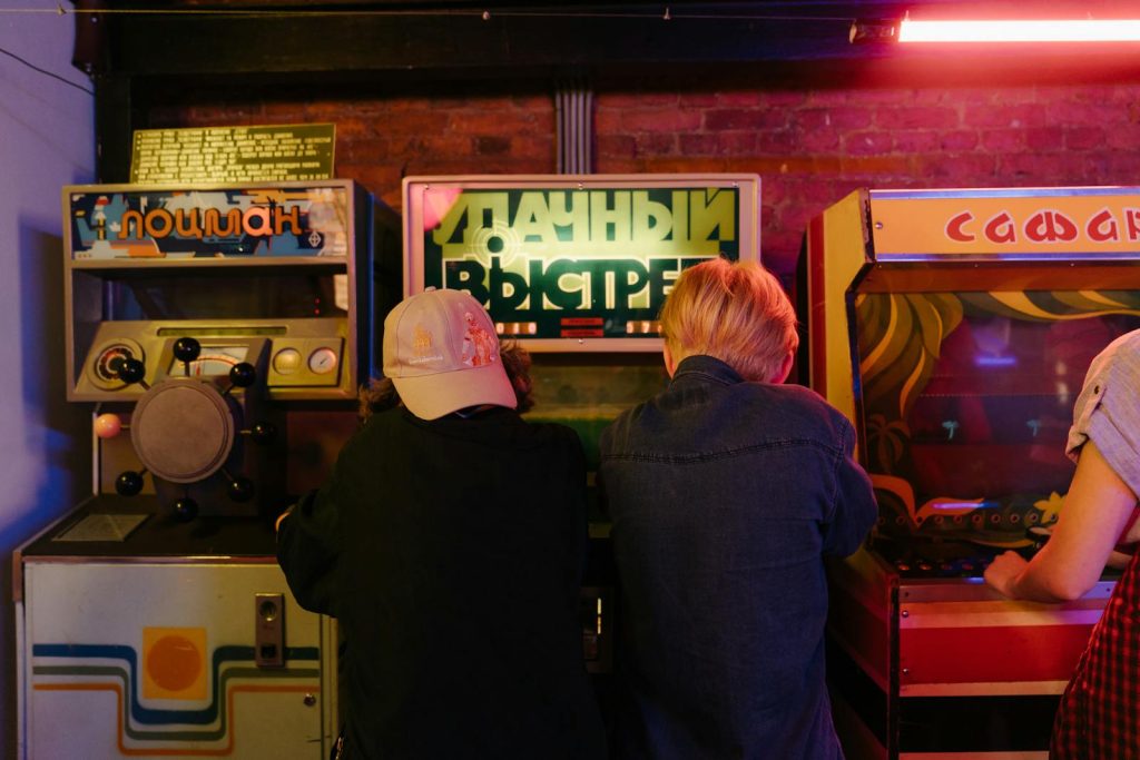 Teenagers enjoying a fun time at a retro arcade with vintage gaming machines.