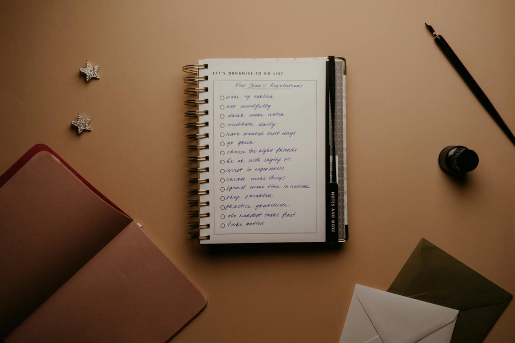 Flat lay of a notebook planner with a handwritten to-do list for effective organization.